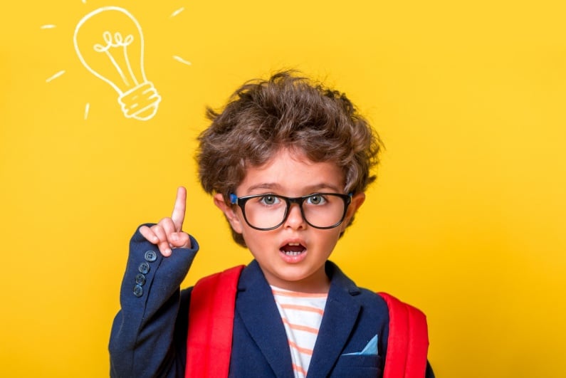 Boy in glasses with lightbulb drawing above head
