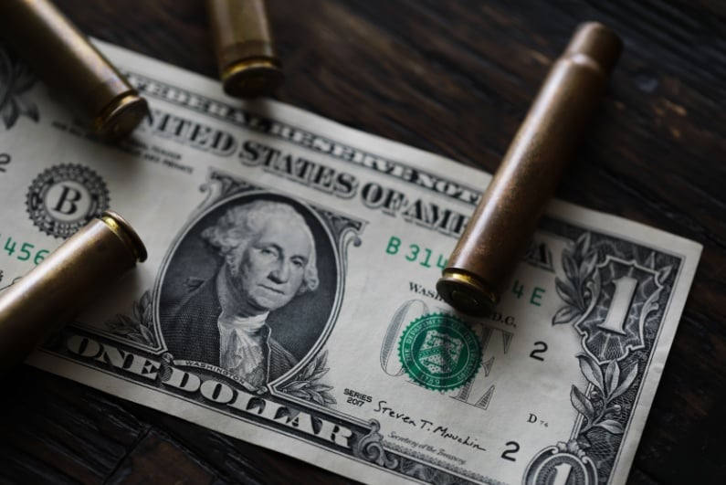 Bullets on top of dollar bill