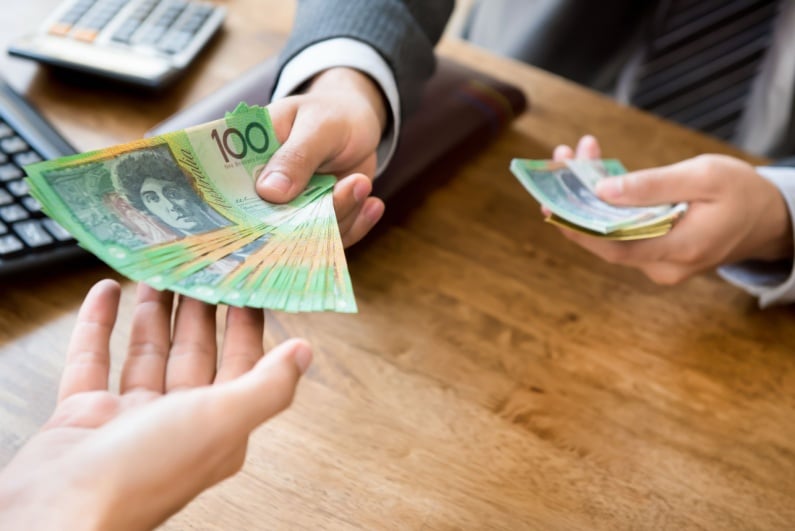 Businessman handing Australian cash to client
