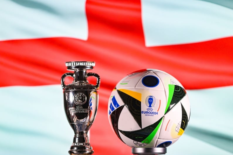 Euro 2024 ball and trophy with England flag in background