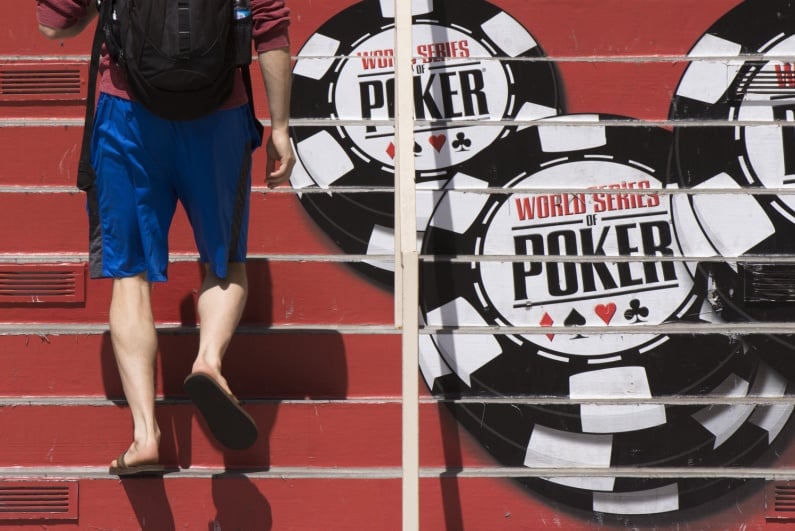 Man walks past WSOP symbol