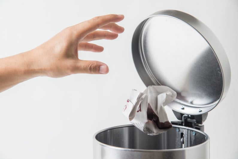 Throwing crumpled paper ball in trash