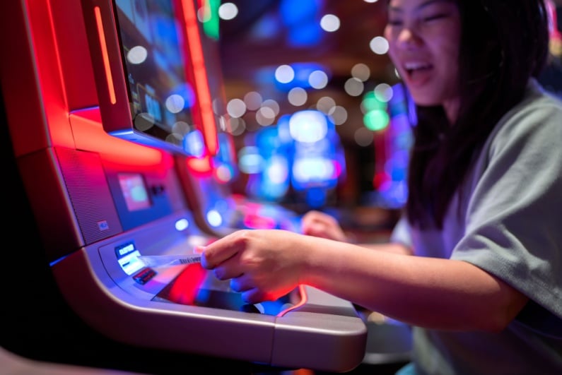 Woman putting money into gambling machine