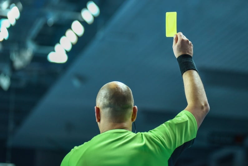 Referee holds up yellow card