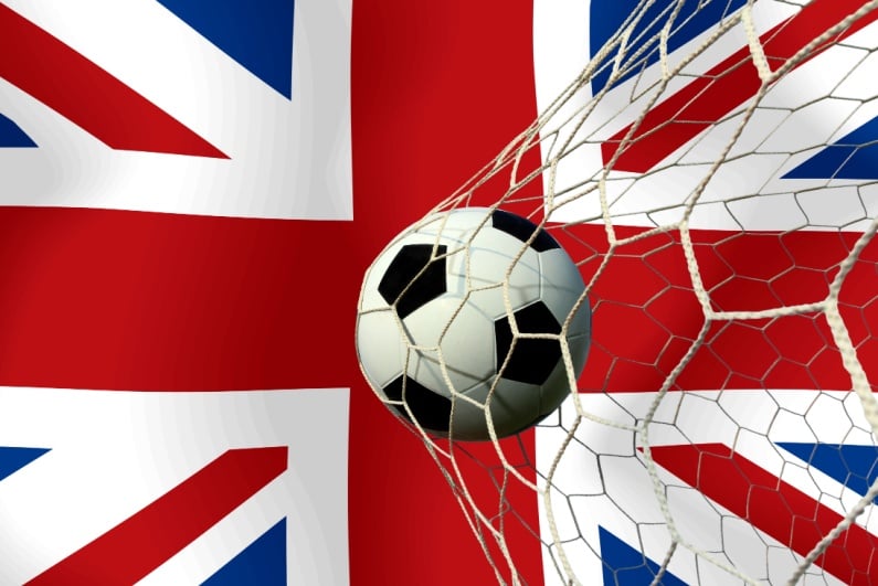 Soccer ball hitting net with UK flag in background