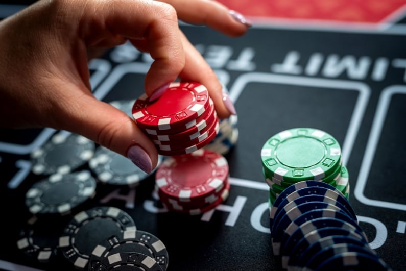 Woman picking up casino chips