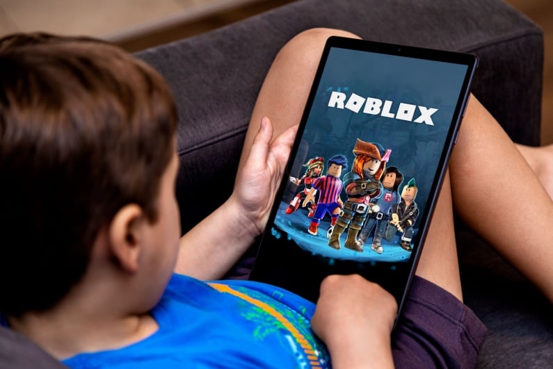 Boy playing Roblox on a tablet