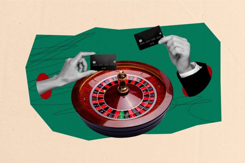 Hands holding credit card above roulette wheel