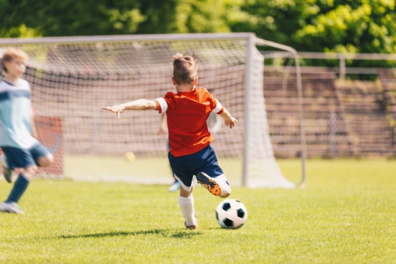 Little boy kicking soccer ball