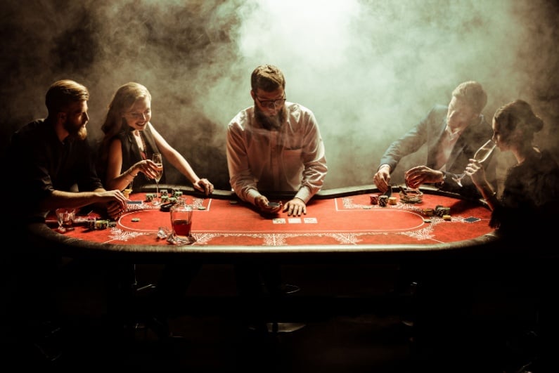 People playing poker at smoky table