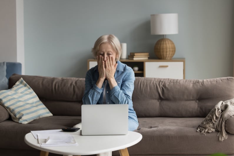 Senior woman looking shocked about something on laptop