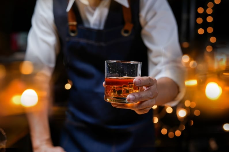 Bartender serving whiskey