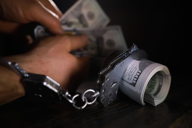 Man in handcuffs with money