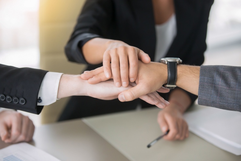 Three businesspeople stacking hands