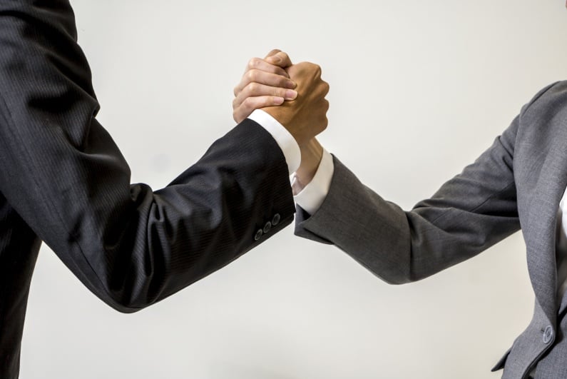 Two businesspeople joining hands