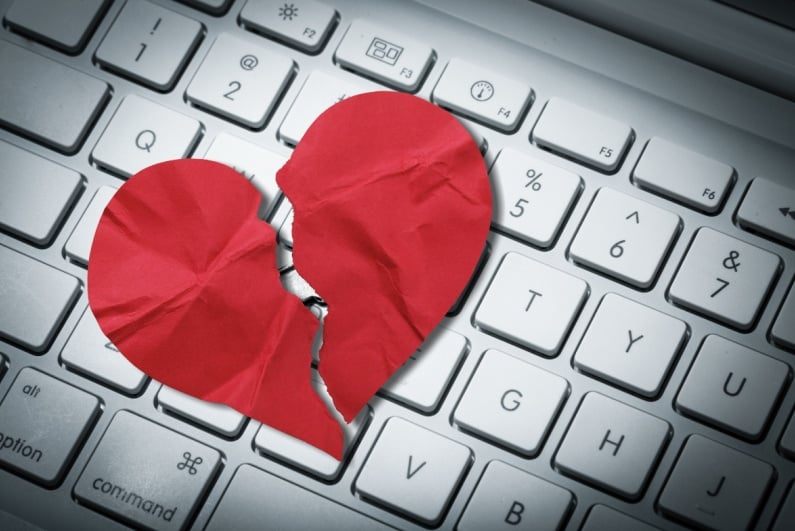 Broken paper heart on keyboard