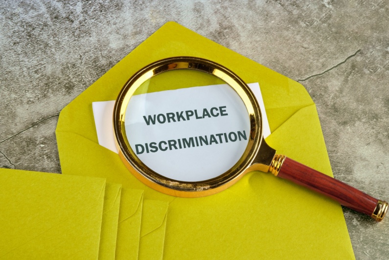 Magnifying glass over paper reading WORKPLACE DISCRIMINATION