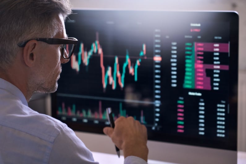 Man looking at stock charts on computer