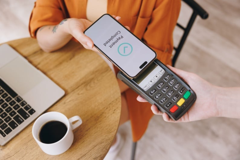 Woman paying for coffee with phone