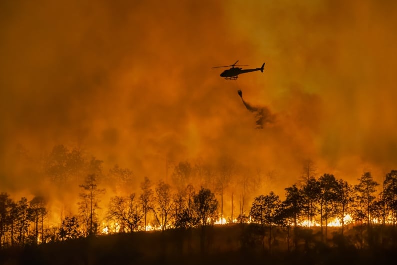 Chopper dumping water on fire