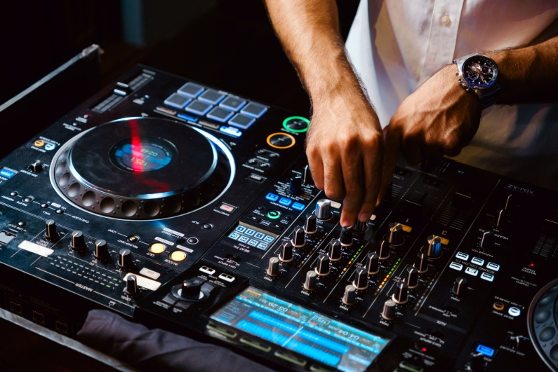 Closeup of DJ's hands mixing at turntable console