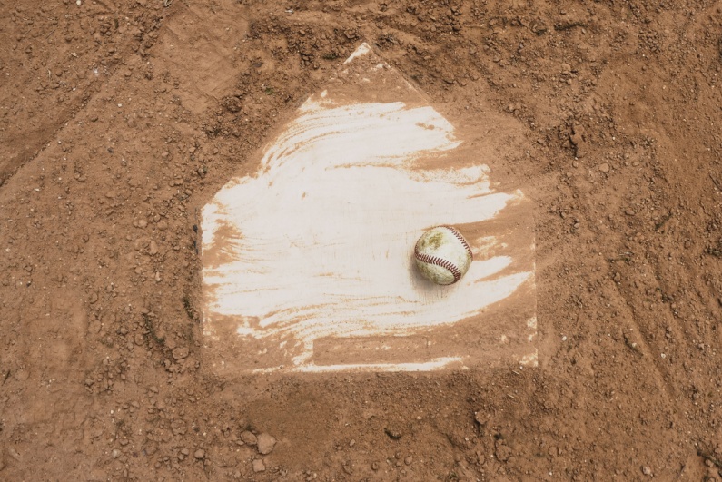 Baseball resting on a dirty home plate