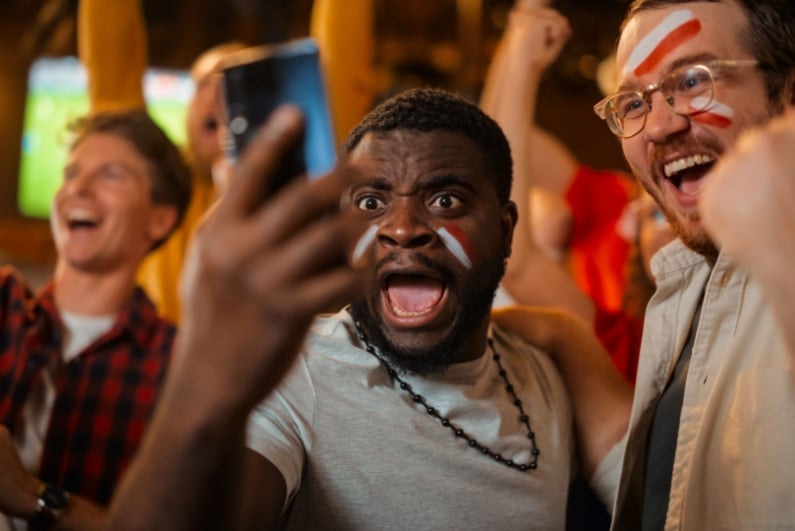 Men celebrating sports bet at sports bar