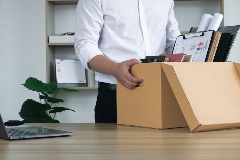 Office worker holding box of belongings