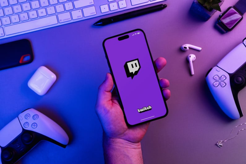 Man holding phone with Twitch logo