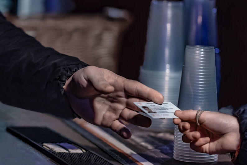 Man showing ID at bar