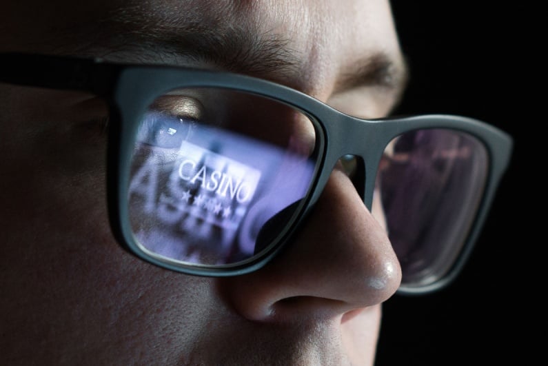 Online casino reflected in man's glasses